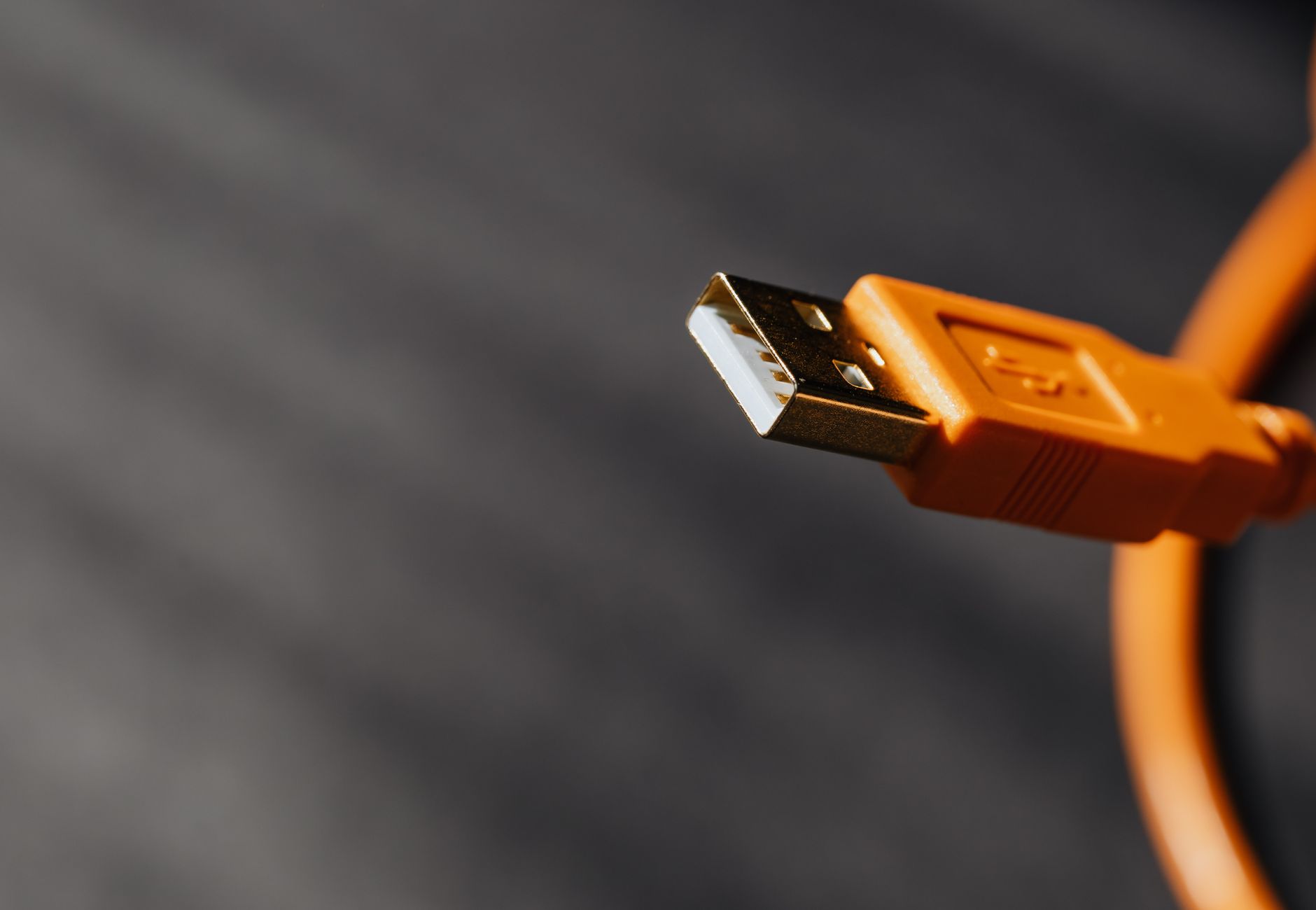Detailed shot capturing an orange USB cable connector on a contrasting background.