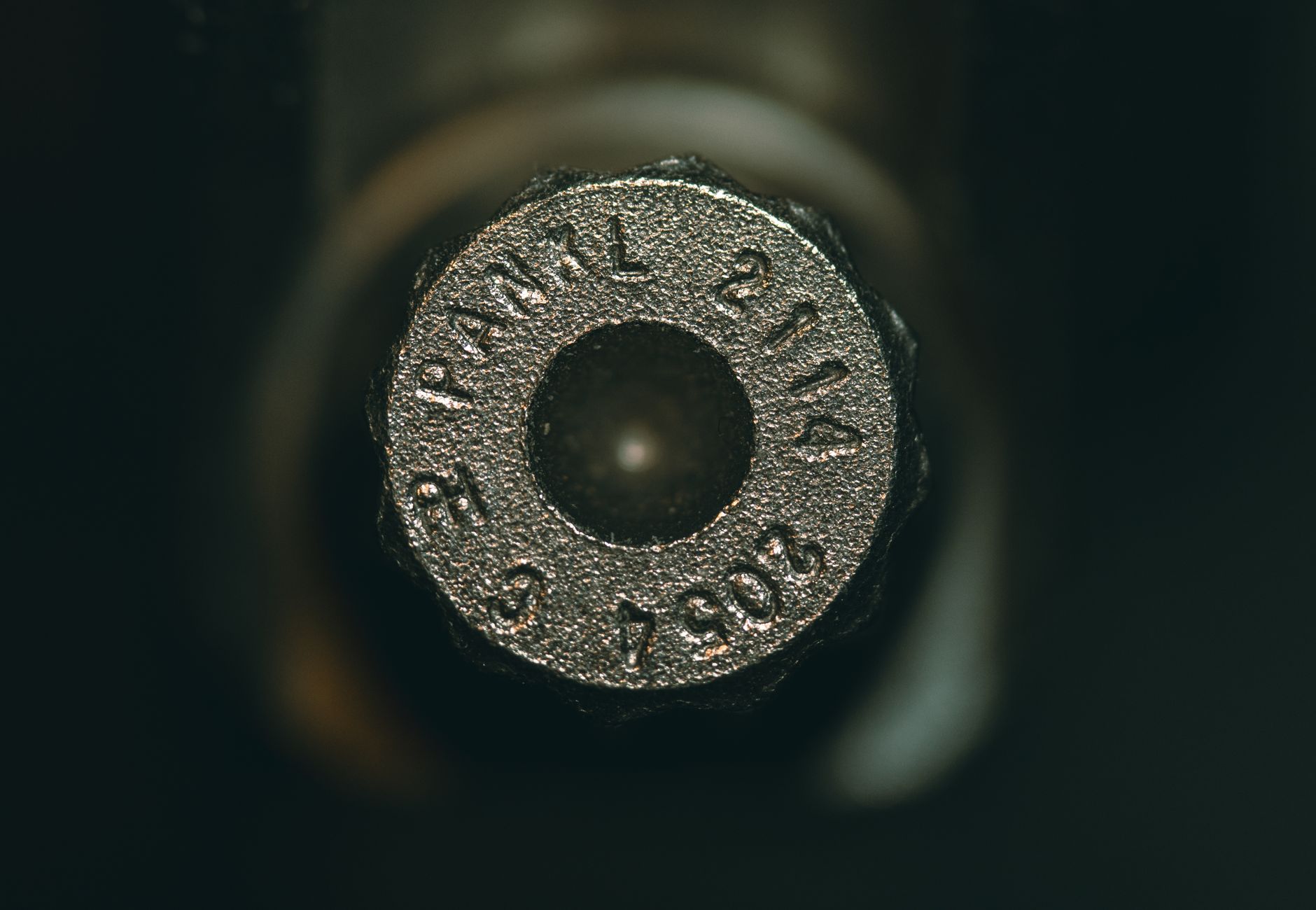 Detailed view of a metallic ammunition cartridge with engraved numbers.