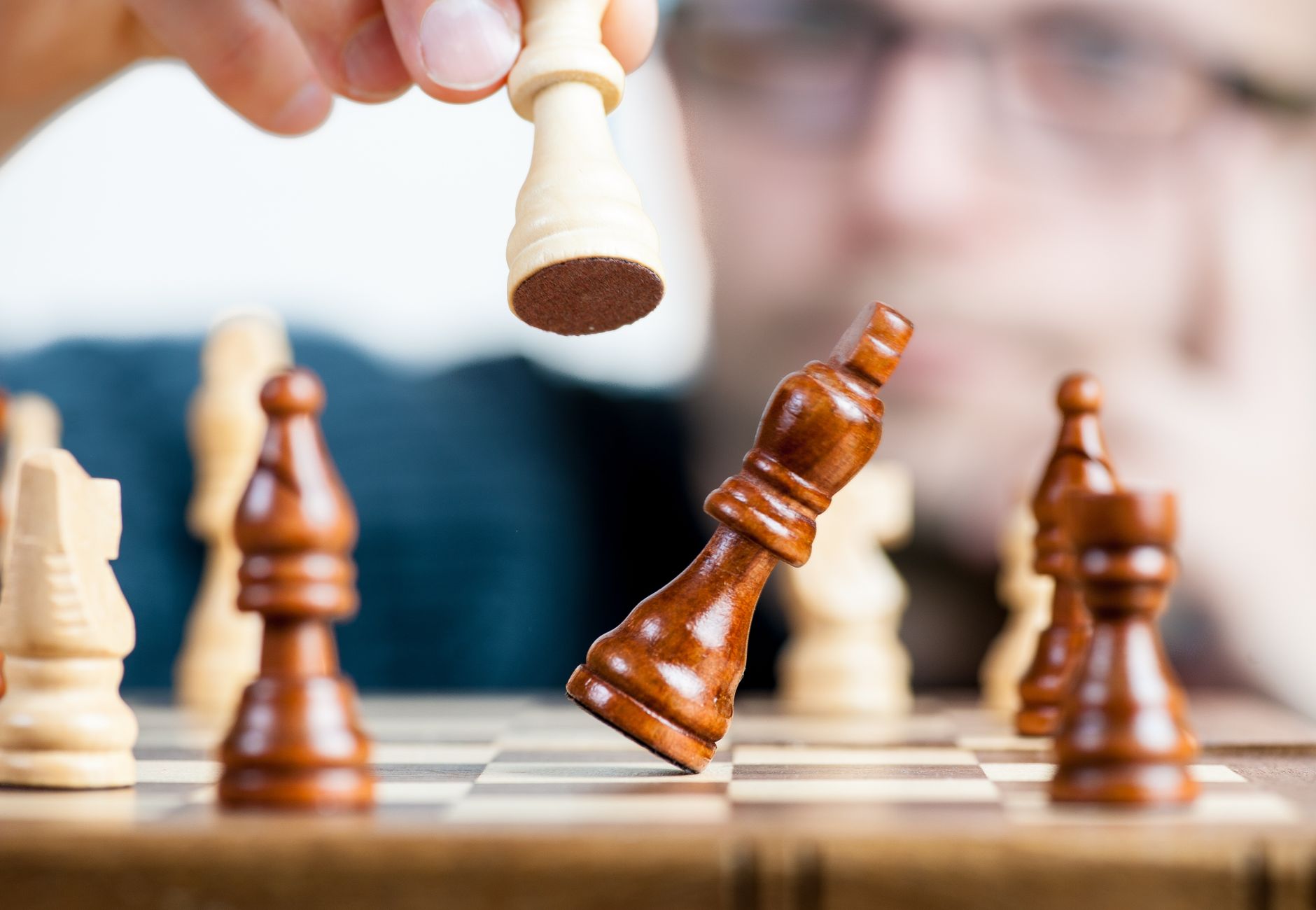 Close-up of a chess game with a focused player, emphasizing strategy and competition.
