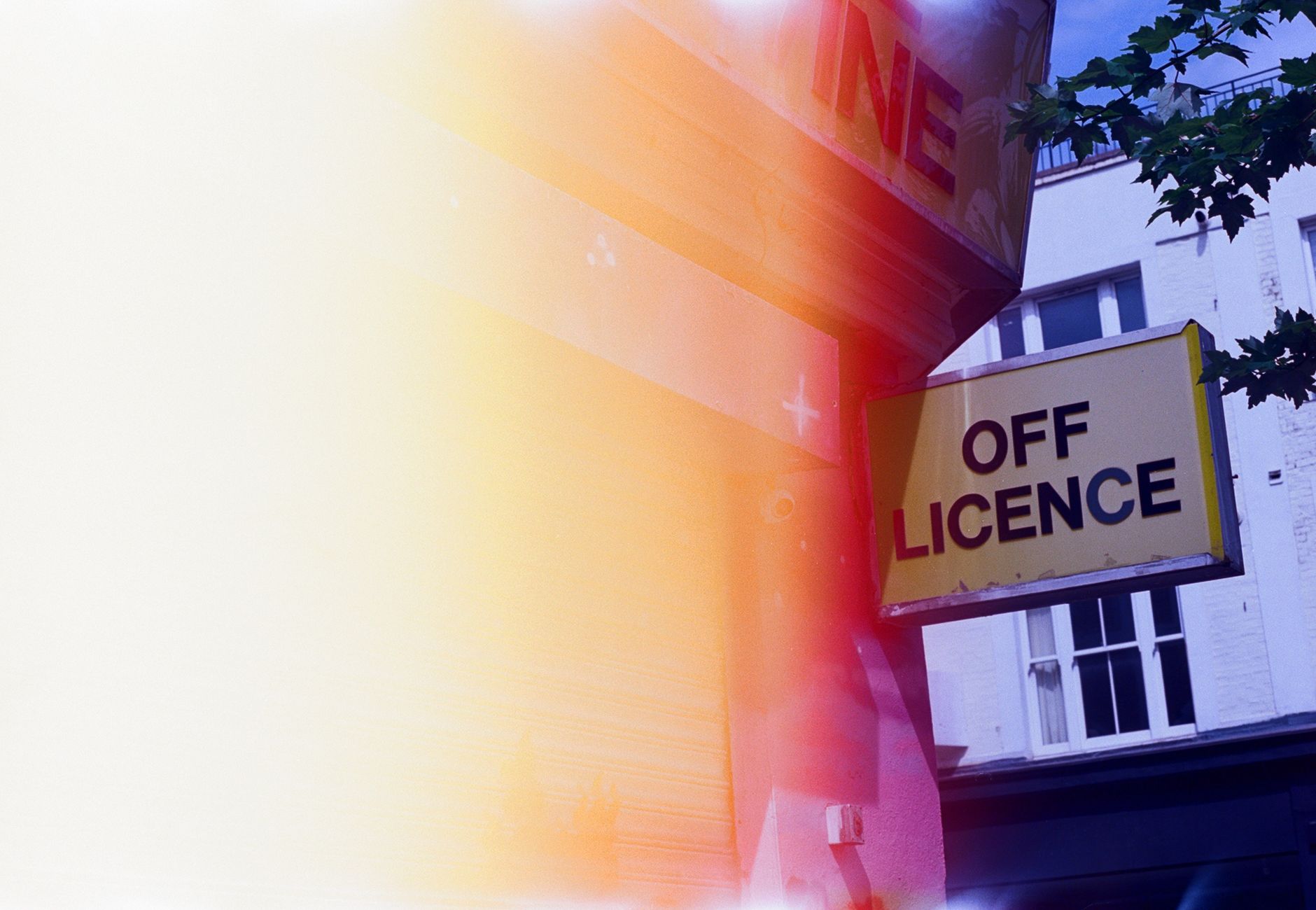 A city off license sign with a vintage vibe and light flare effect, creating urban nostalgia.