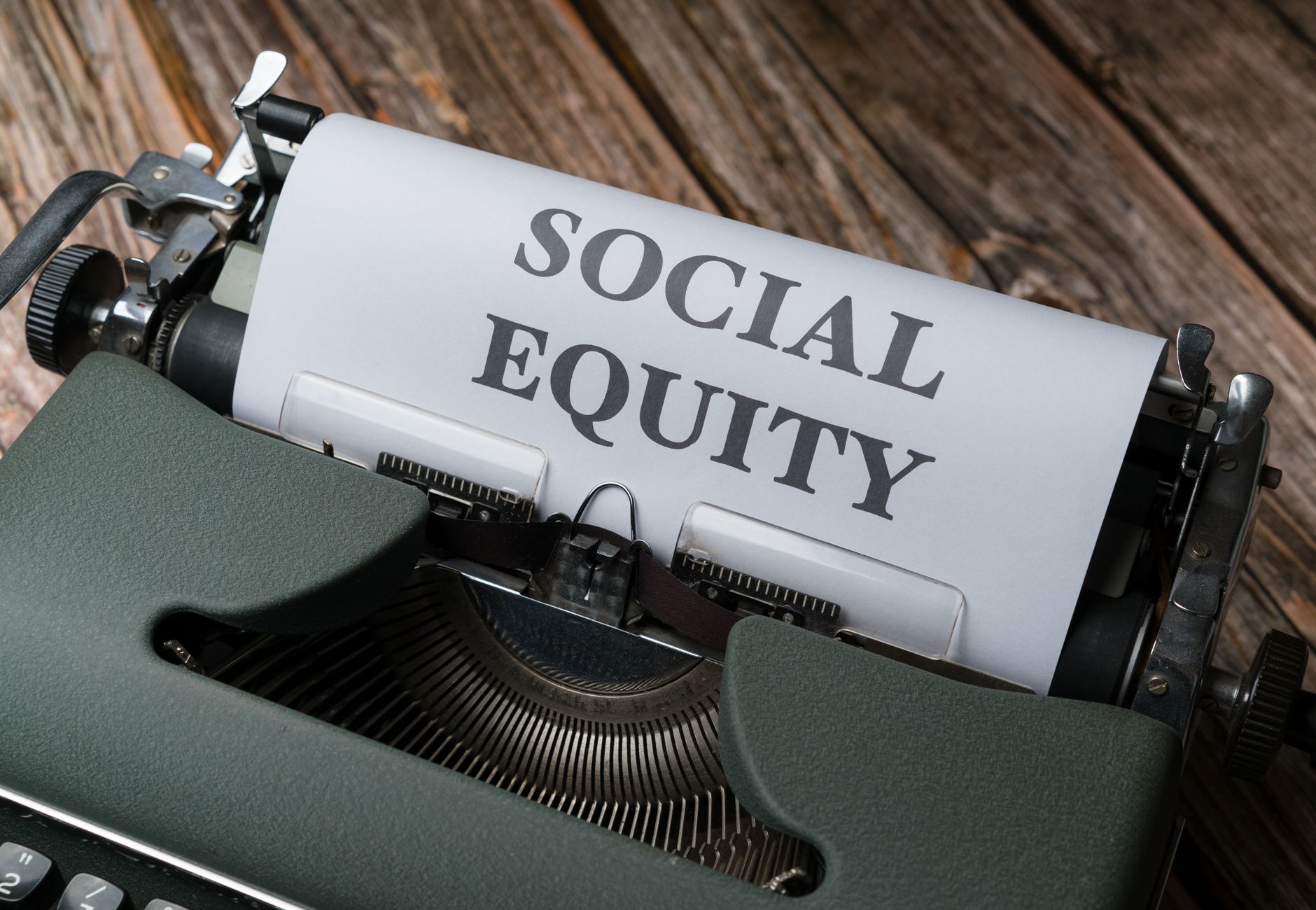 Close-up of a vintage typewriter displaying the message 'Social Equity' on paper.