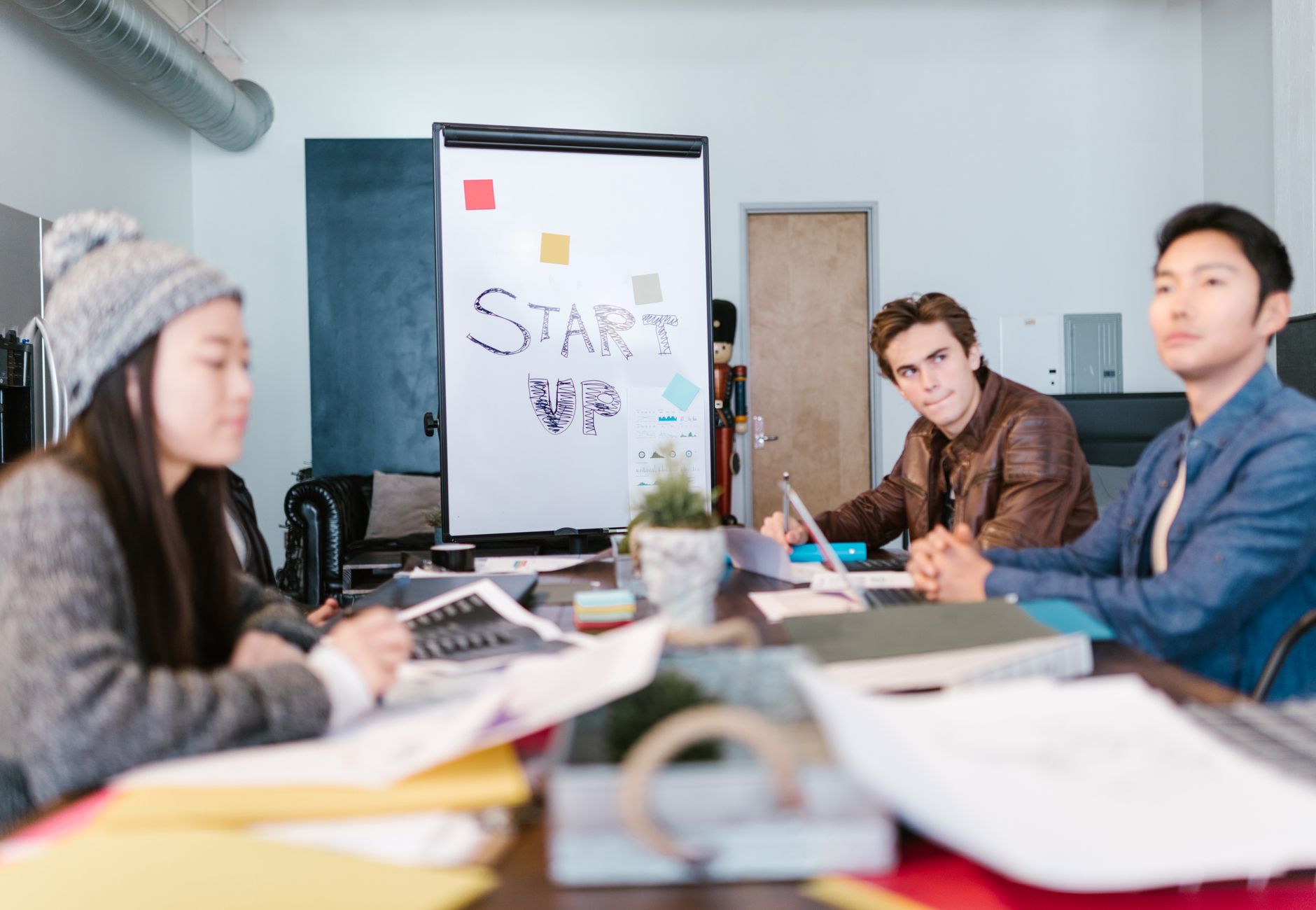 A group of young professionals brainstorming ideas in a startup office setting.