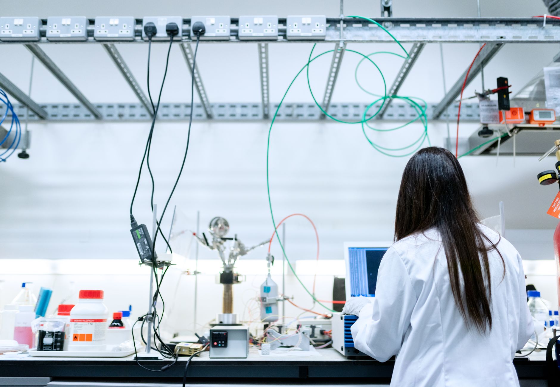A female scientist conducting research in a contemporary laboratory full of equipment.