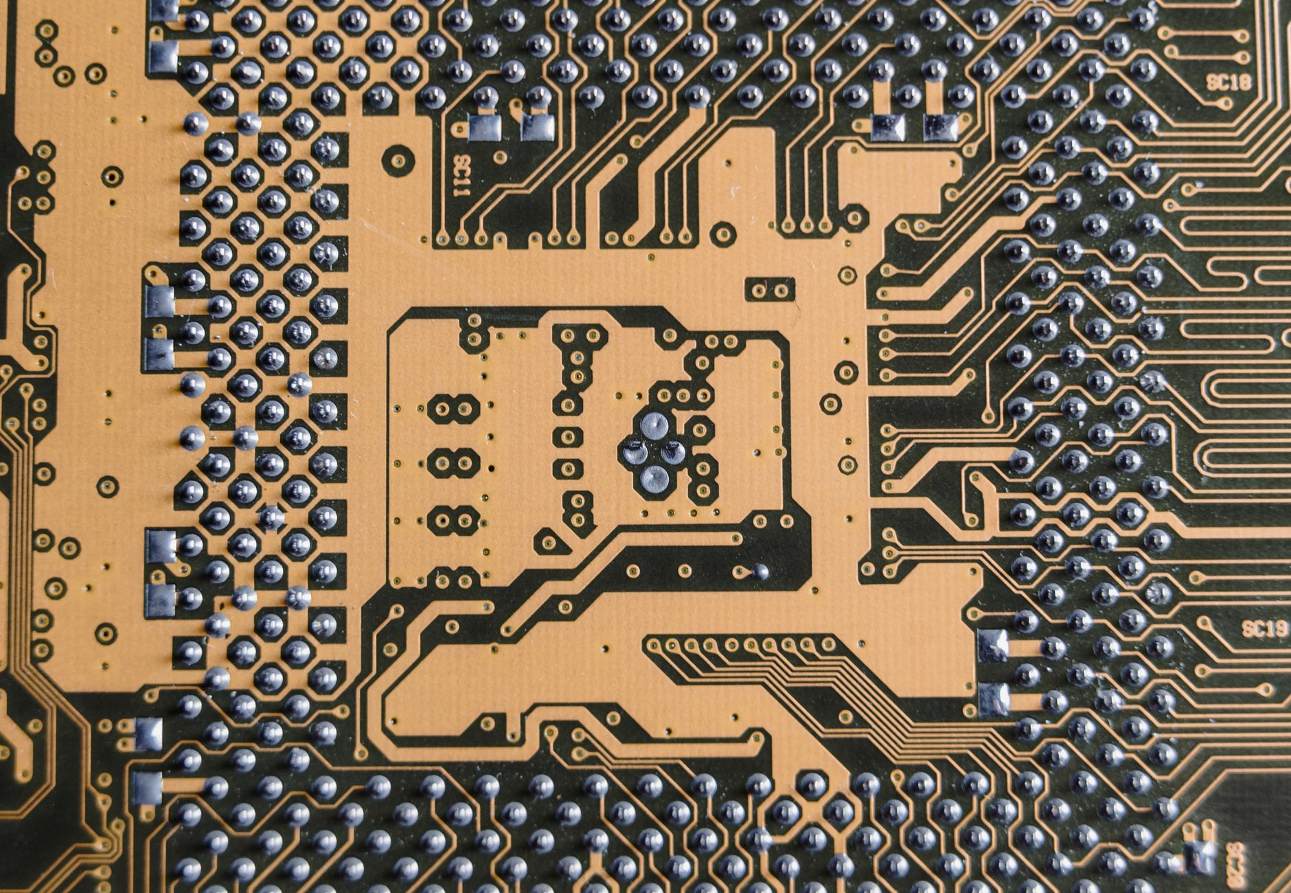 Detailed view of a circuit board showcasing intricate patterns and metallic connections.